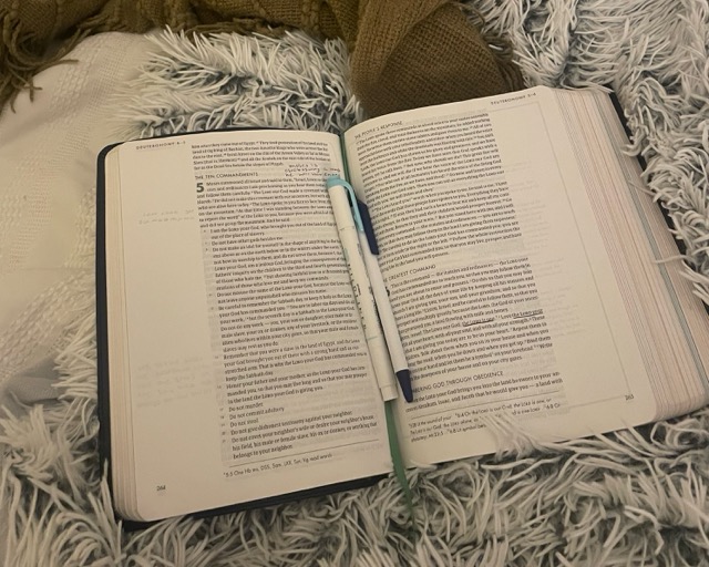 Bible open with writing utensils
